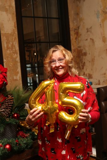 Ann Bilodeau at our 2023 Staff Recognition event holding 45 years of service balloons.