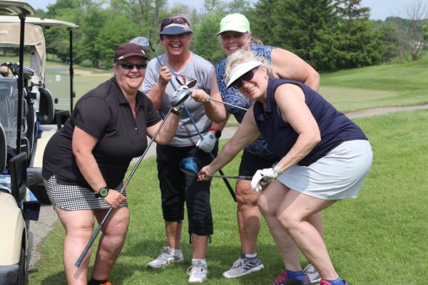 Four participants posing with their golf clubs at KW Habilitation's 2023 Annual Golf Tournament.