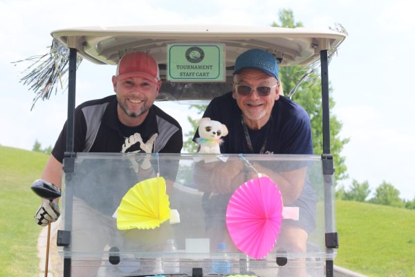 Staff smiling in a golf cart at KW Habilitation's 2023 Annual Golf Tournament.