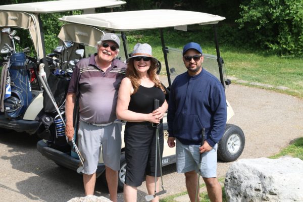 Three participants posing with their golf clubs at KW Habilitation's 2023 Annual Golf Tournament.